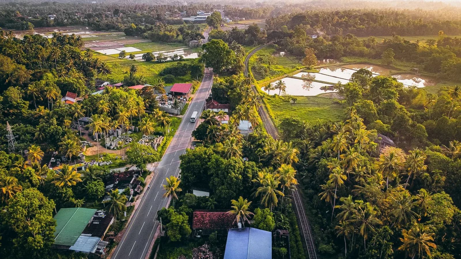 Bird's-eye view across lush tropical forests and undulating mountain terrain.